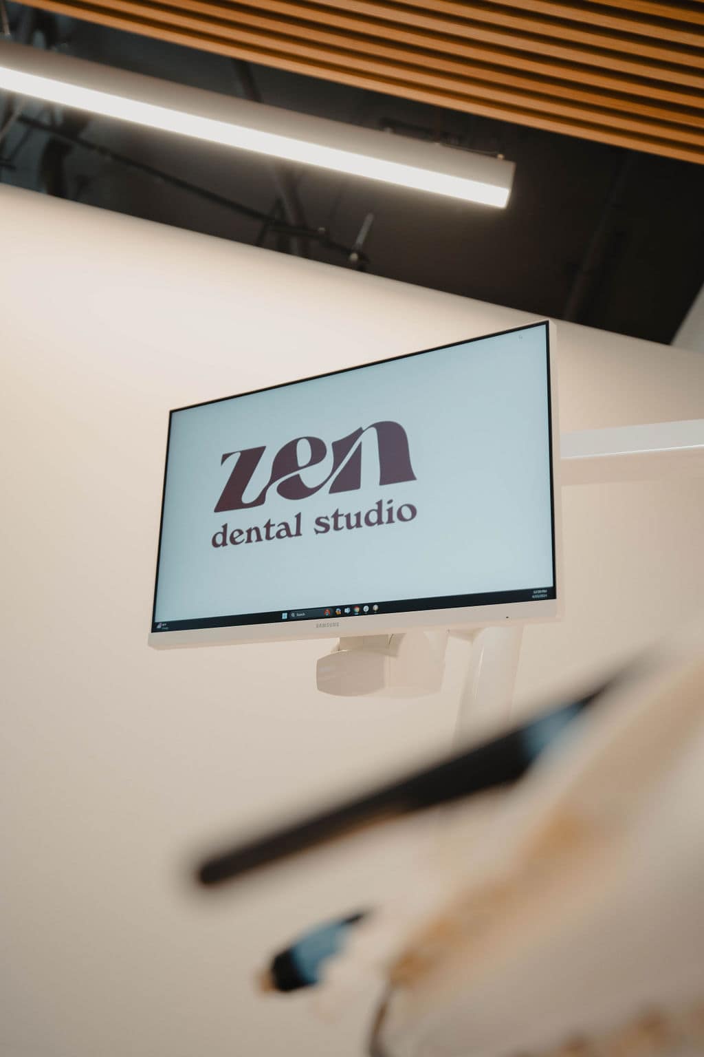 A chairside monitor in a Zen Dental Studio operatory, showing the studio's mark on screen