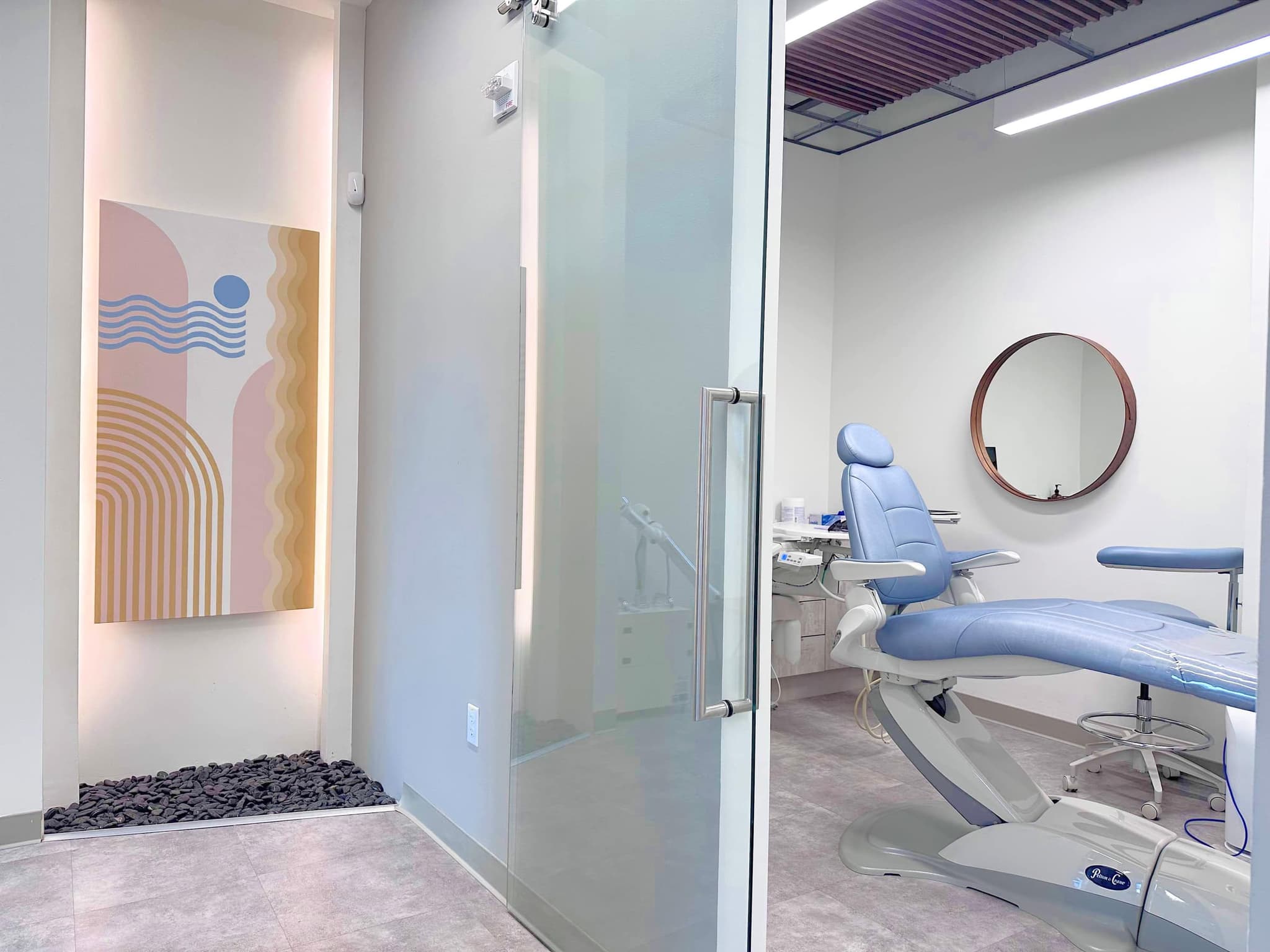 A treatment room at the San Francisco studio, with a pale blue chair and a pastel wall panel