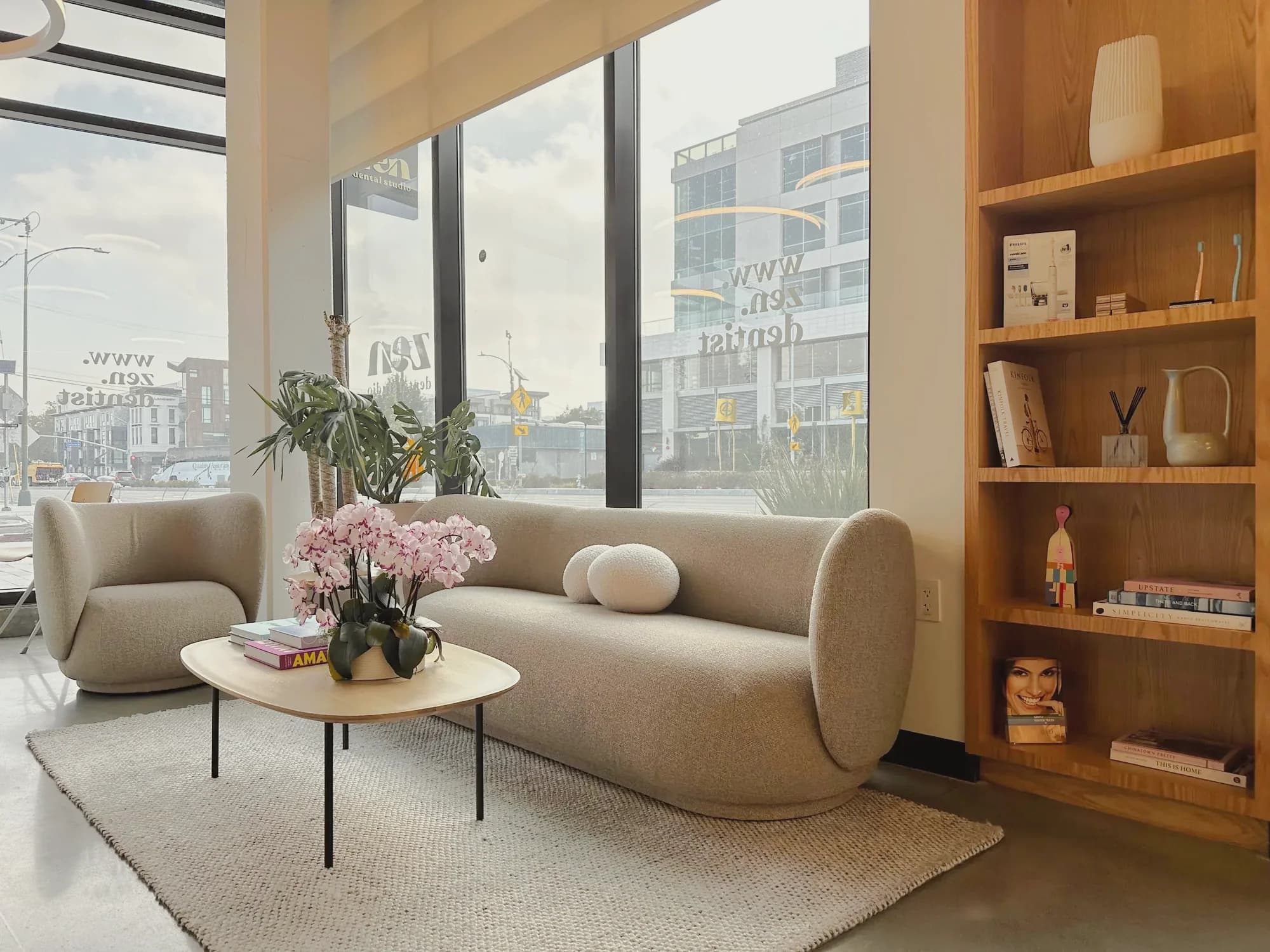 The lounge at the Mountain View studio, with a soft sofa, orchids on the coffee table, and an oak bookshelf by the windows